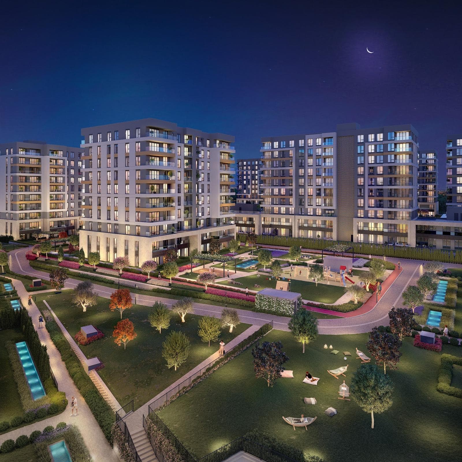 Night rendering of the lit blocks around the courtyard, with the looping walking track, playground and lawns in the foreground