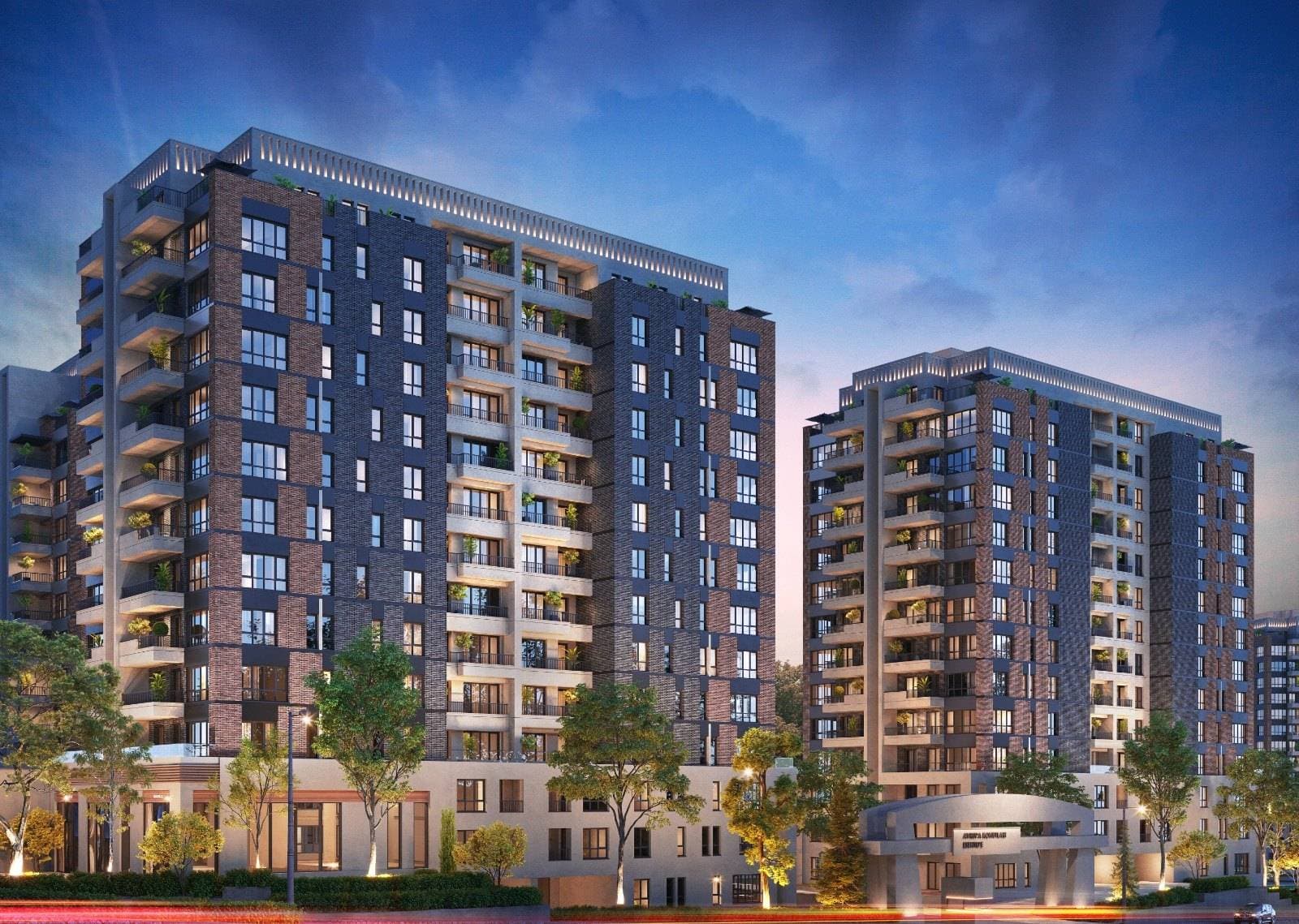 Residential blocks lit up at dusk above a curved entrance canopy