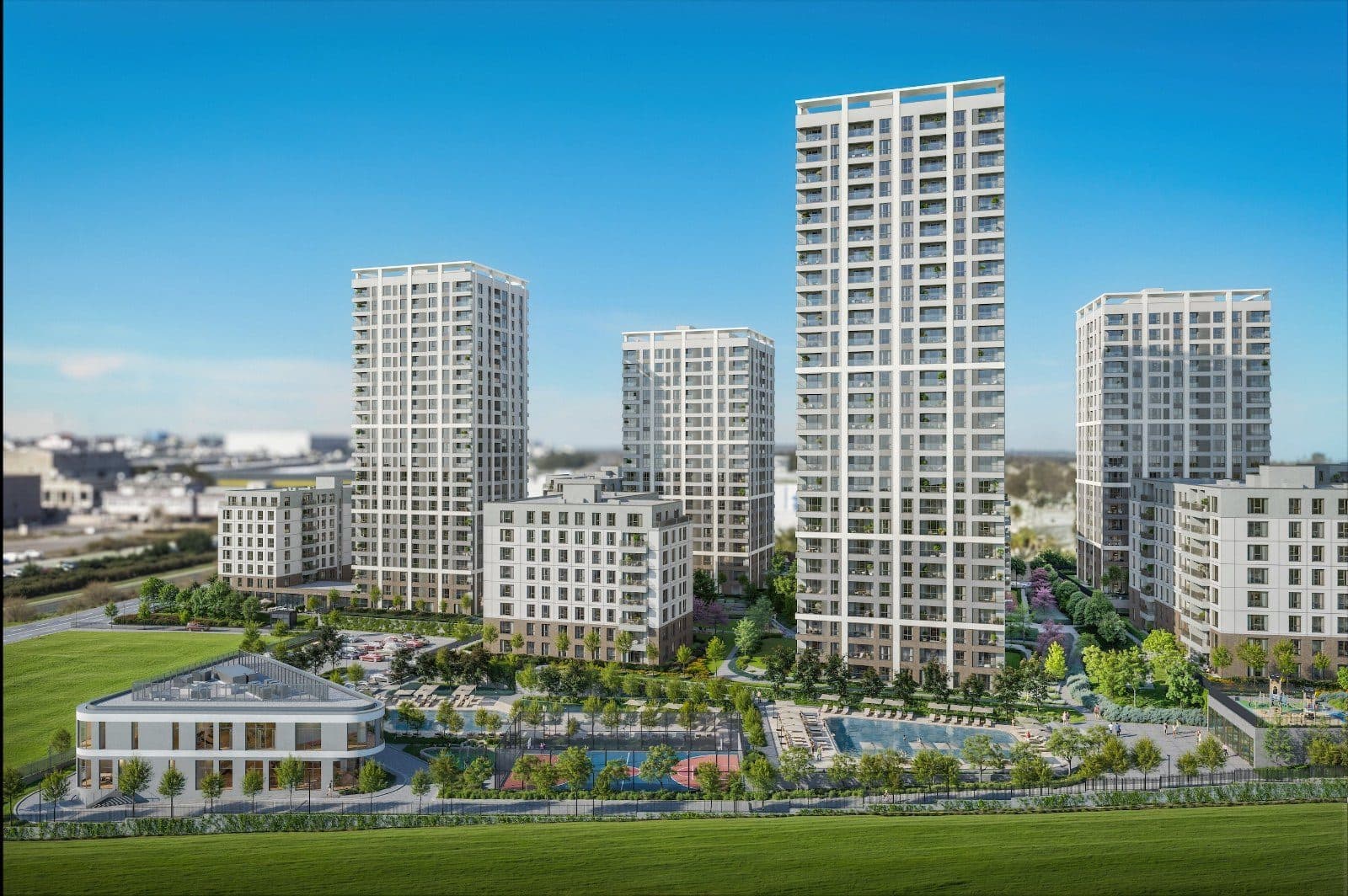 Rendered view of the Bahceada towers and mid-rise blocks behind a lawn, with the social facility building, swimming pools and a sports court in front