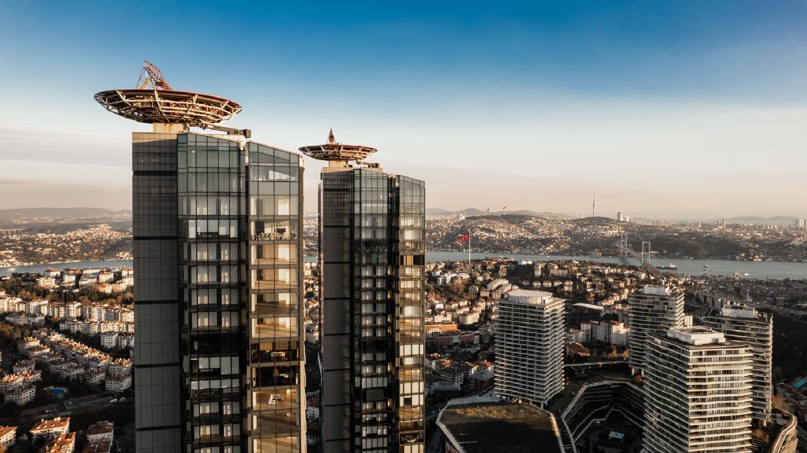 Top floors of the two towers with their rooftop helipads, the Bosphorus behind