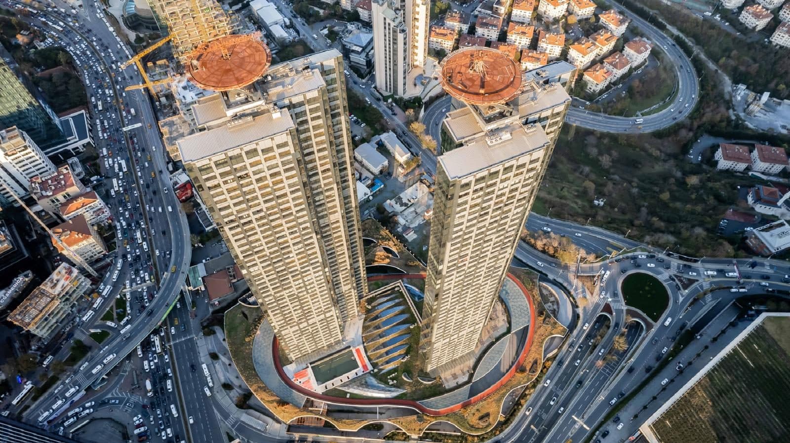 View from directly above the towers, showing the rooftop helipads, the outdoor pool and the red running track on the podium