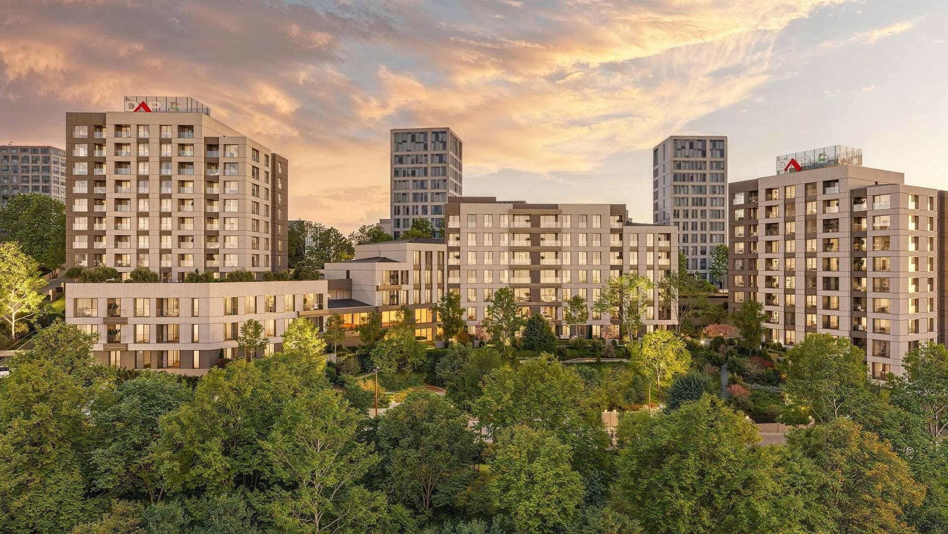 The blocks of the project rising above the treetops at sunset, with the Atasehir towers behind