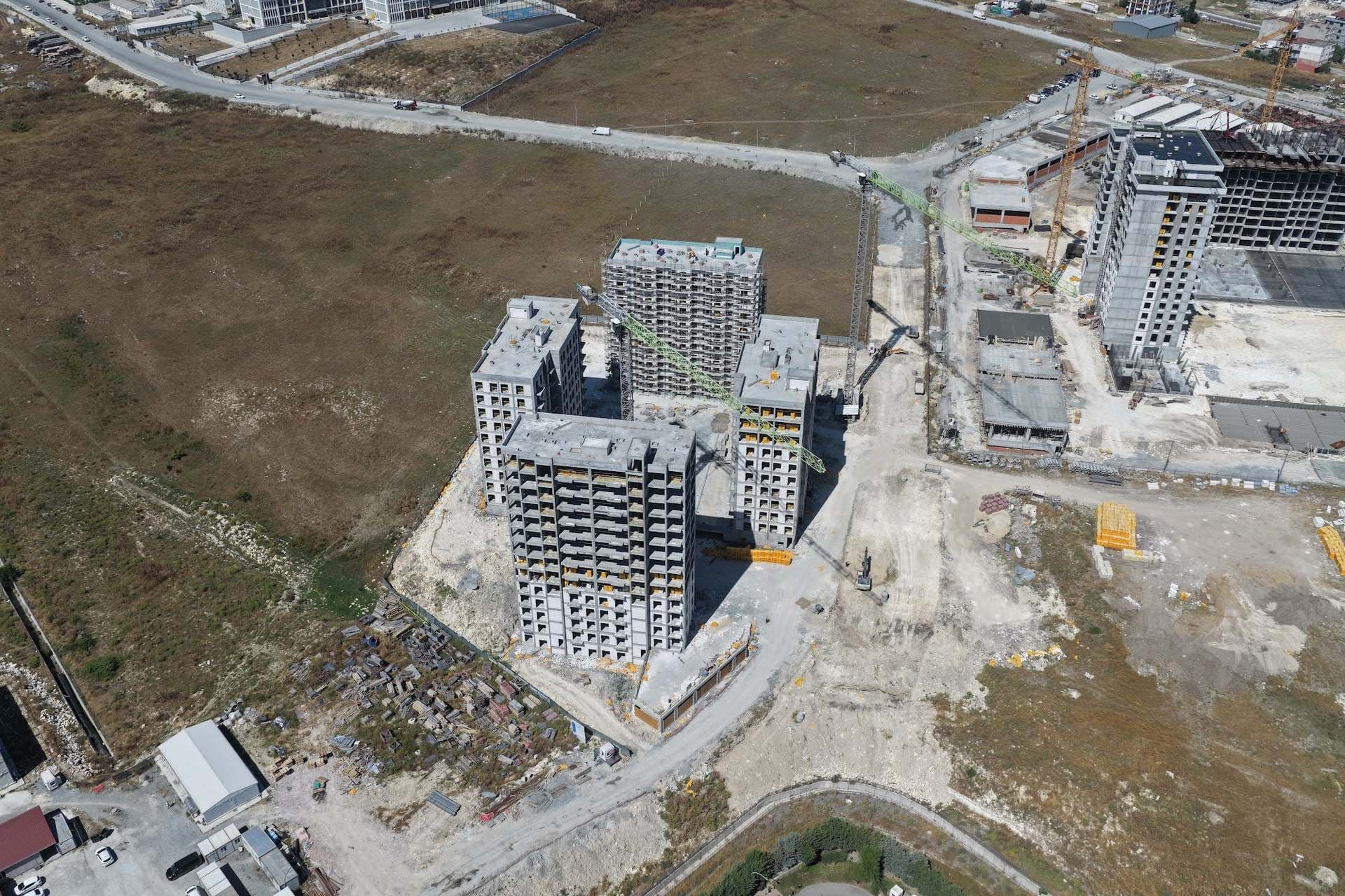 Aerial drone photo of the four blocks under construction around the courtyard, with a tower crane on the site