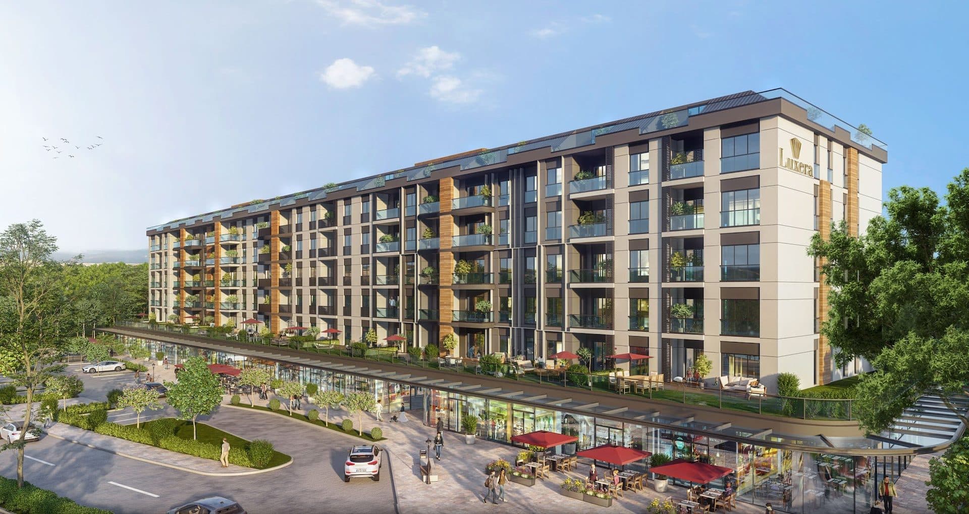 Rendered view of the glazed shop arcade with cafe seating and the first-floor terraces above it, beside a road and parking spaces