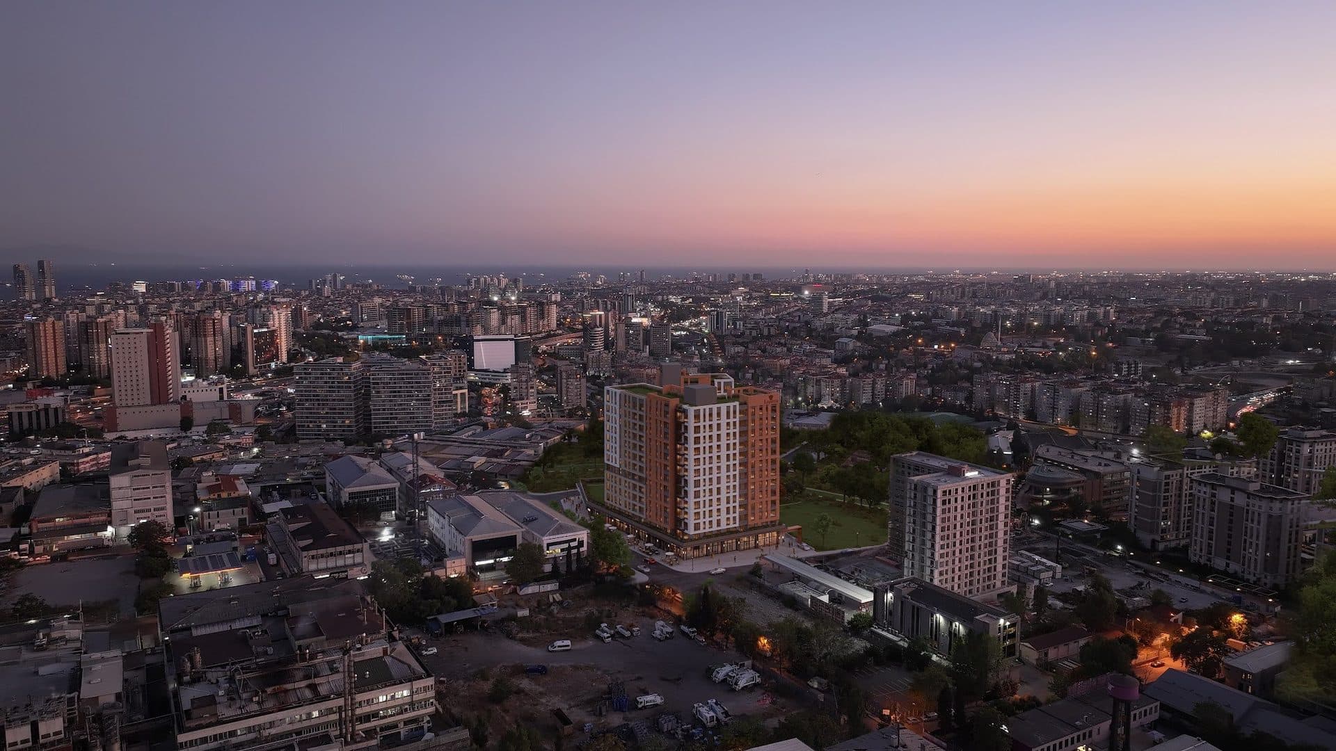 Aerial view at dusk with the project rendered into a photo of the surrounding city