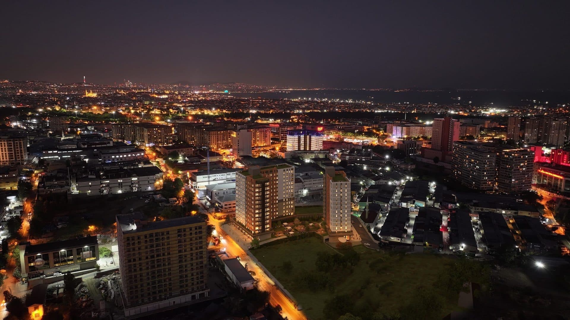 Night aerial view with the lit blocks rendered into a photo of the surrounding streets