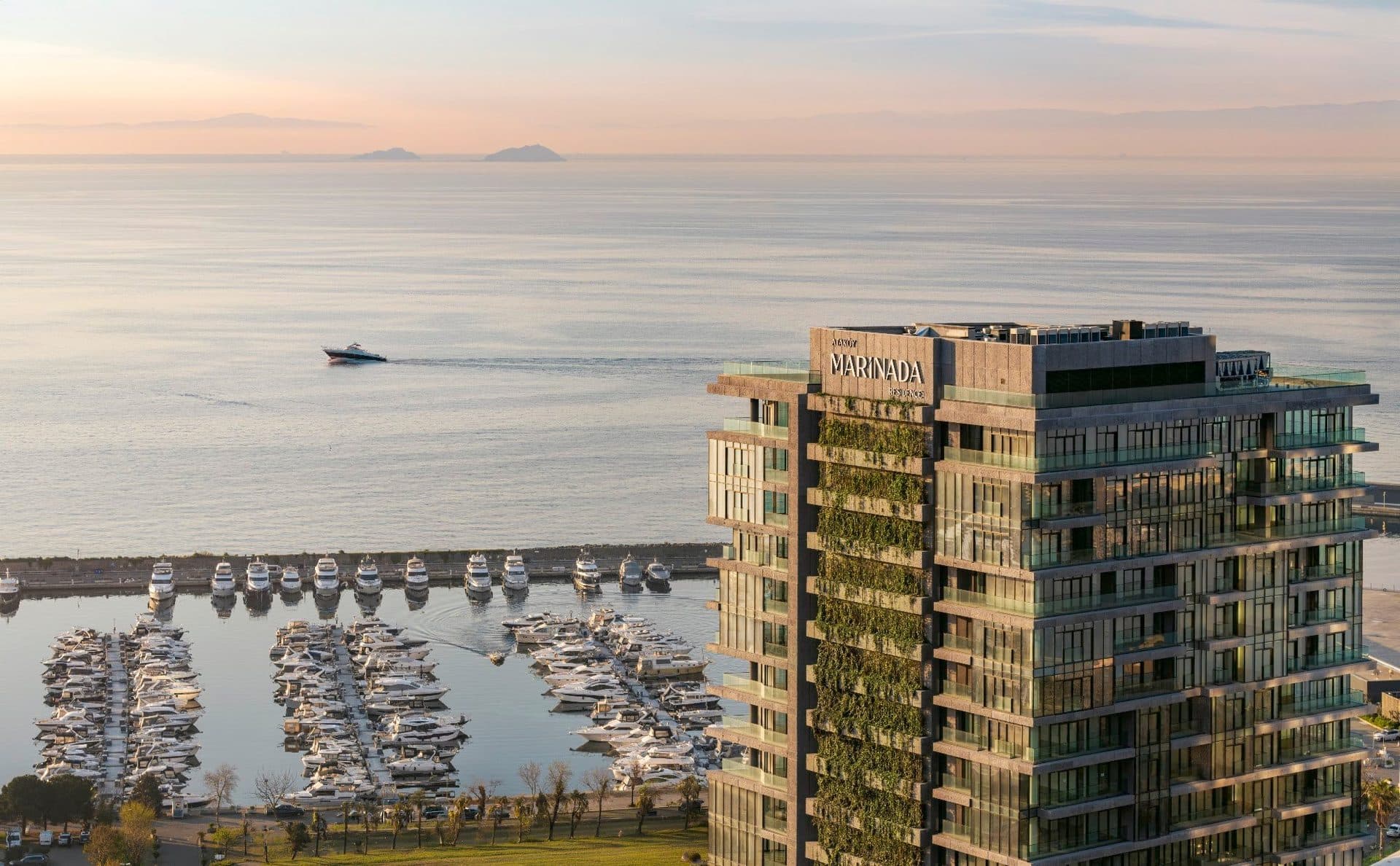 Upper floors of the tower with its name on the crown, overlooking the marina and the sea