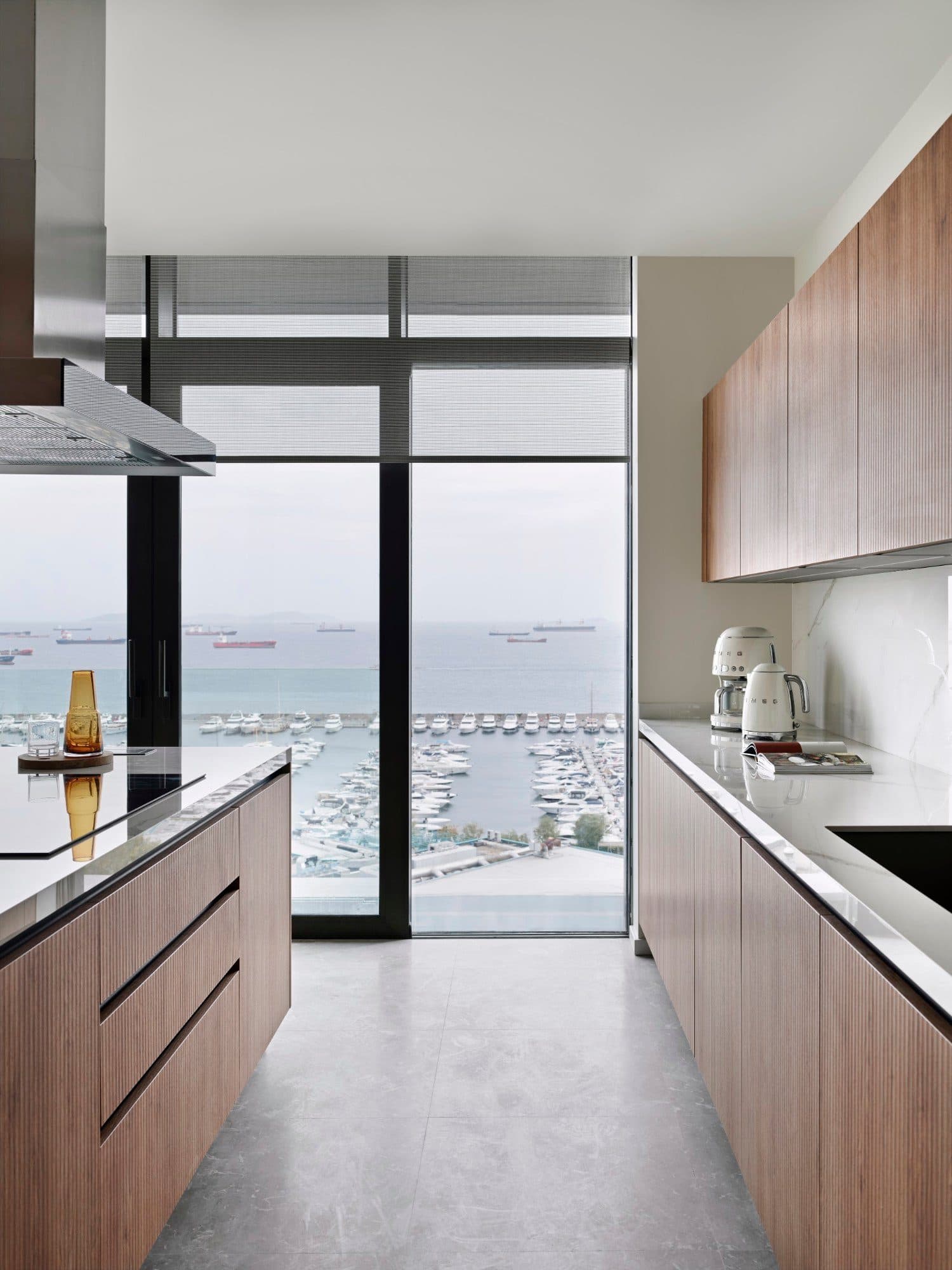 Kitchen island and built-in units beside a full-height window looking over the marina