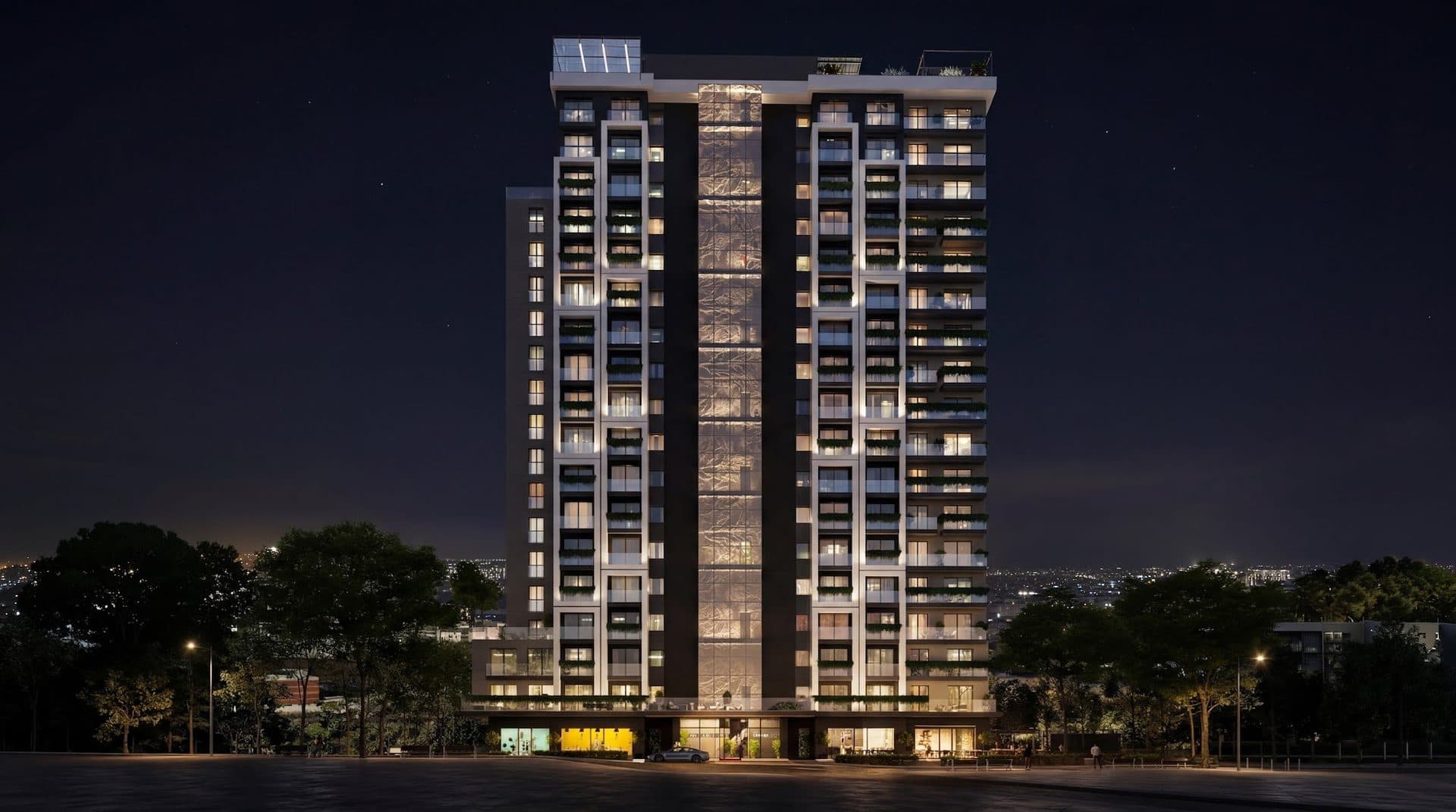 Rendering of the full height of the tower at night, with a lit vertical glass core between two wings and shops at street level