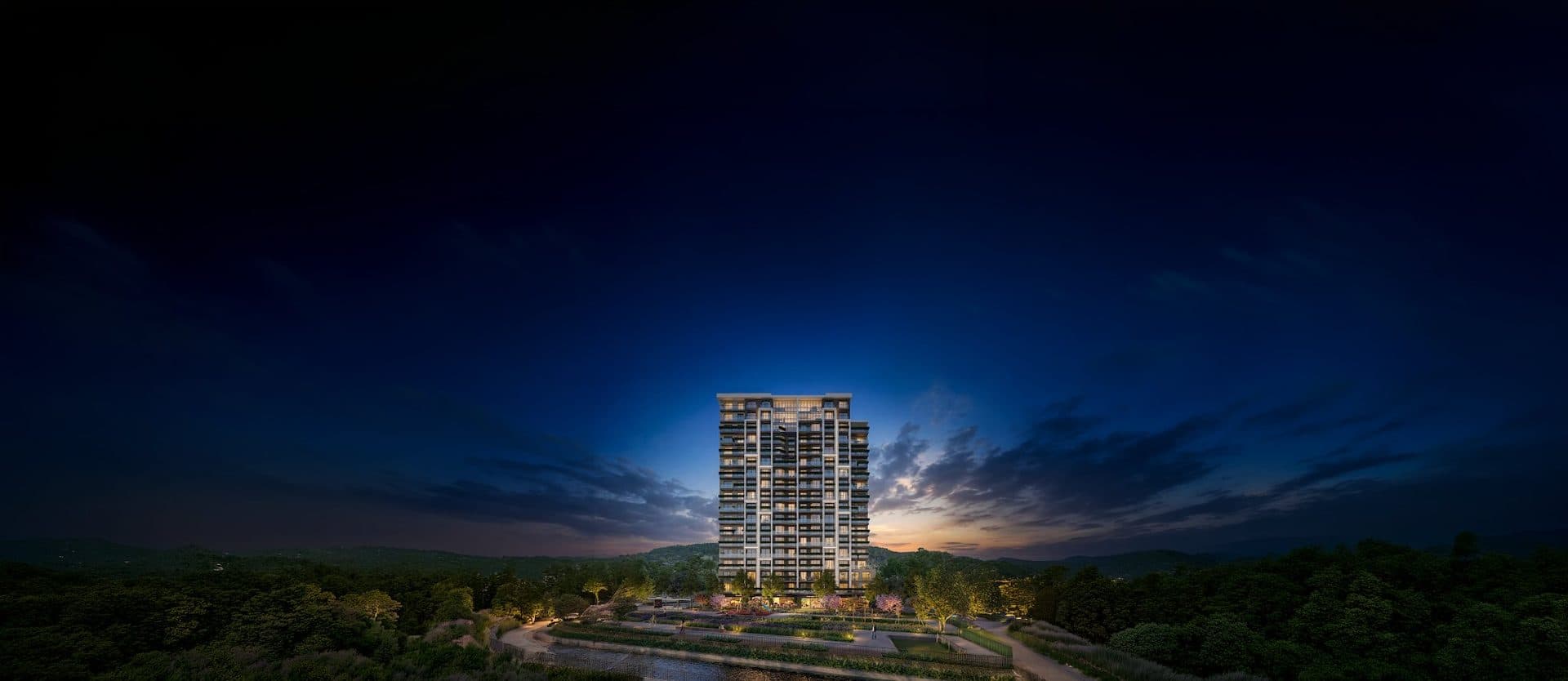 Wide night rendering of the single tower rising above forested hills and a landscaped garden under a deep blue sky