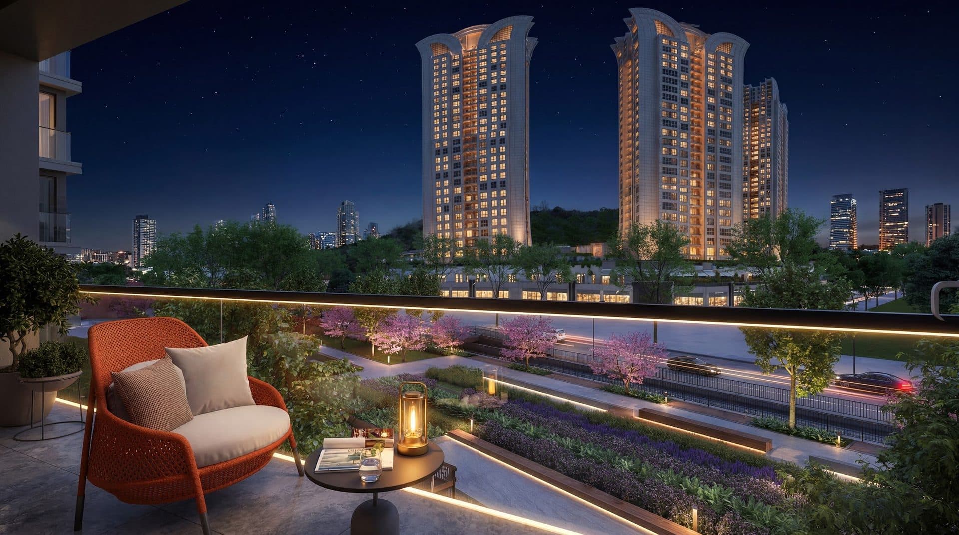 Rendering of a terrace armchair at night overlooking a landscaped strip with blossoming trees, a road and neighboring residential towers
