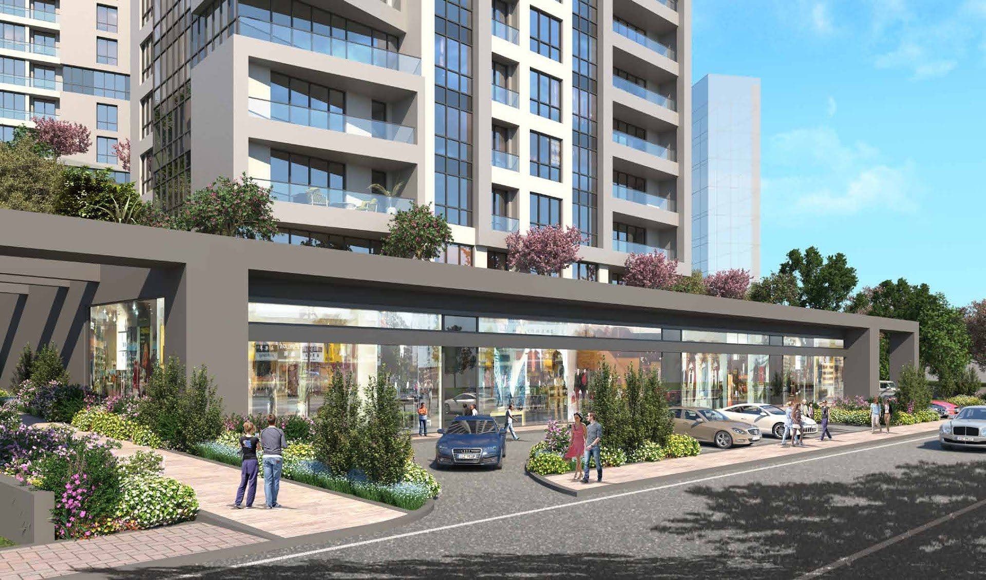 Shop fronts under a covered walkway along the street, with planted beds and the residential block above