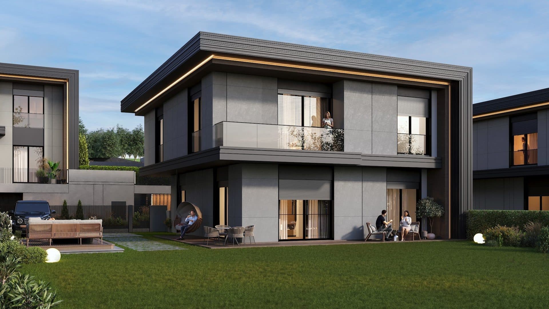 Villa facing its lawn at dusk, with terrace seating and neighboring villas on both sides