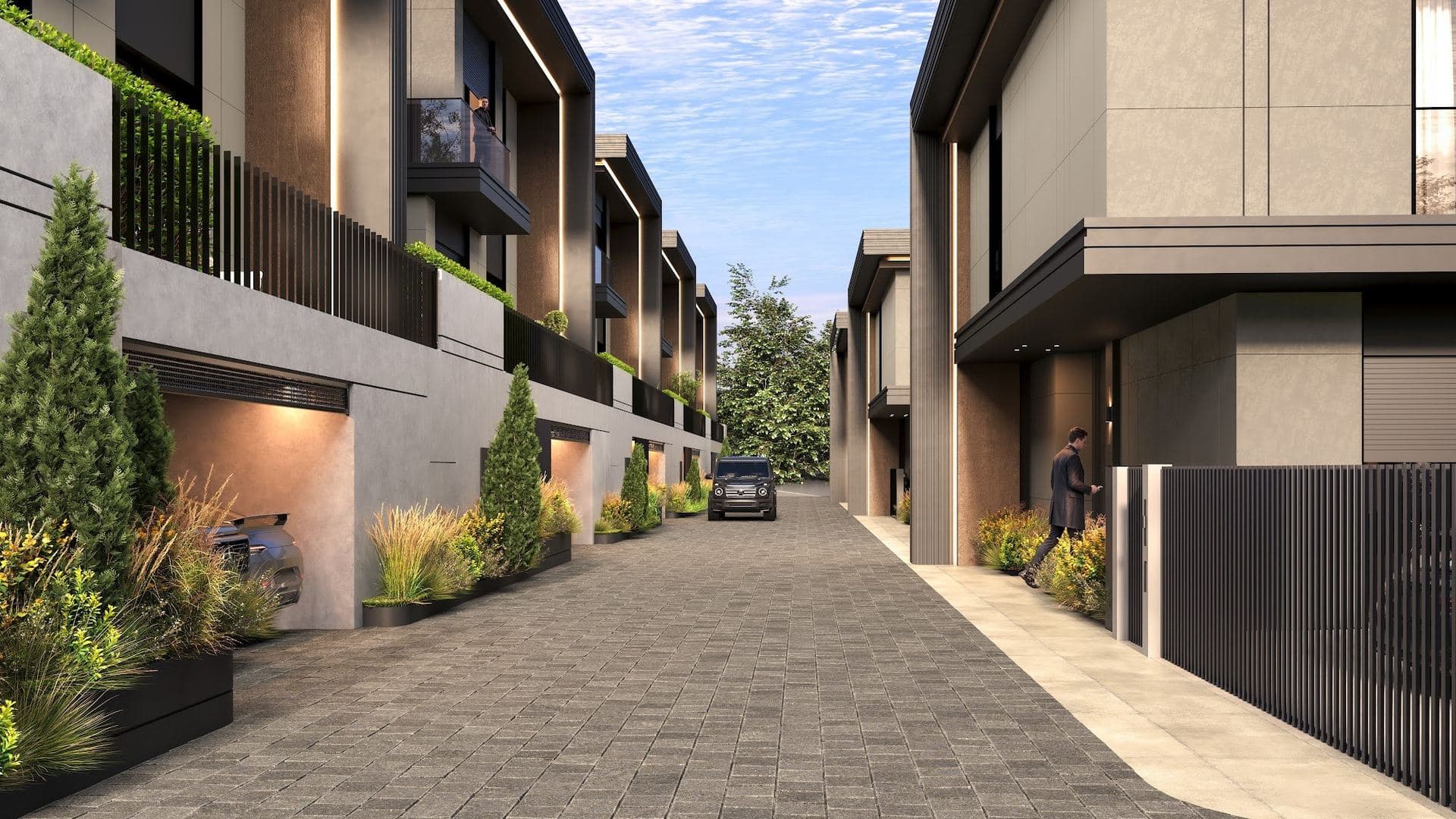 Paved inner road between the villas, lined with planters, garage entrances and front gates