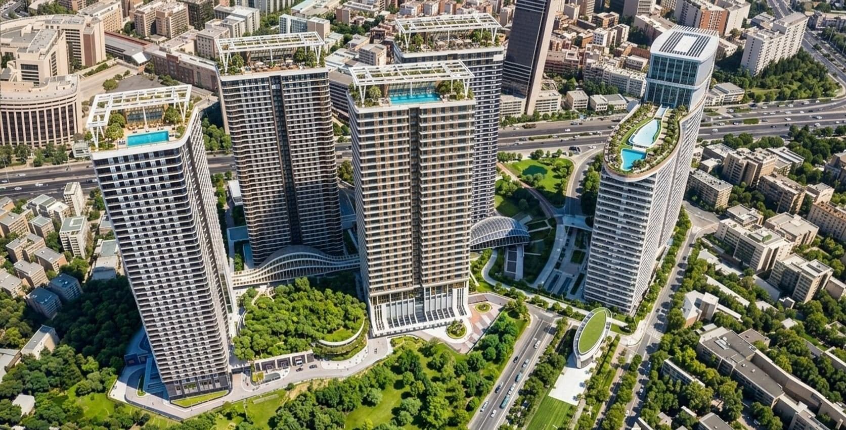 Aerial view of the Tasyapi Sisli towers in Sisli, with pools on their roofs, a landscaped garden and a curved canopy between the buildings