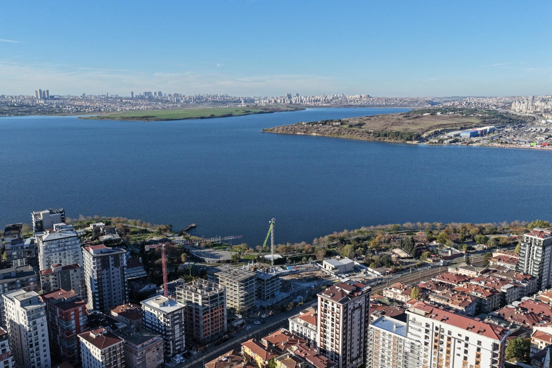 Drone view over Kucukcekmece Lake, with the Yali 360 construction site and its cranes on the near shore in November 2025