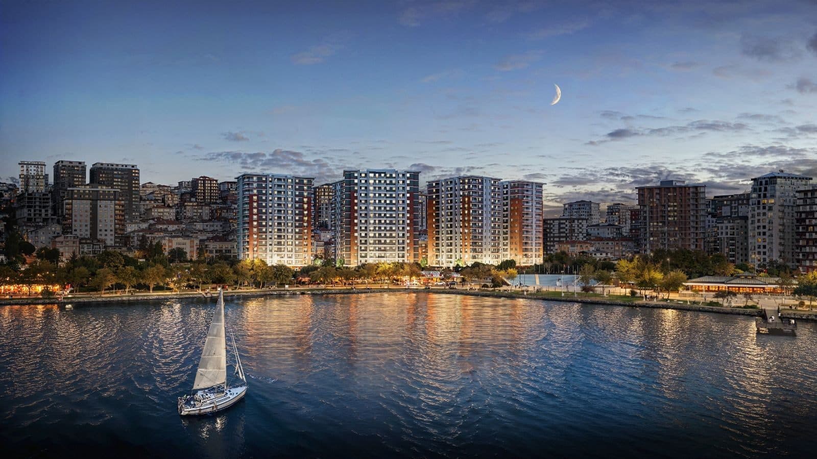 Yali 360 towers lit up at dusk, seen across Kucukcekmece Lake with the lakeside park in front