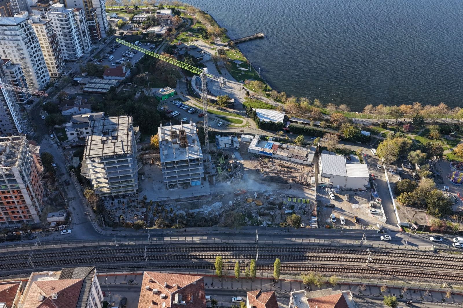 Drone view from above of the Yali 360 site in November 2025, with two tower frames rising between the railway and the lakeside park