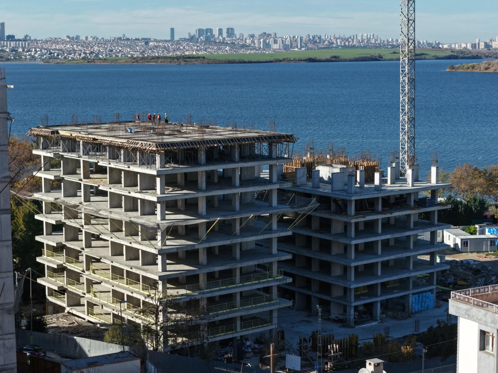 Concrete frames of two Yali 360 towers under construction in November 2025, with Kucukcekmece Lake behind